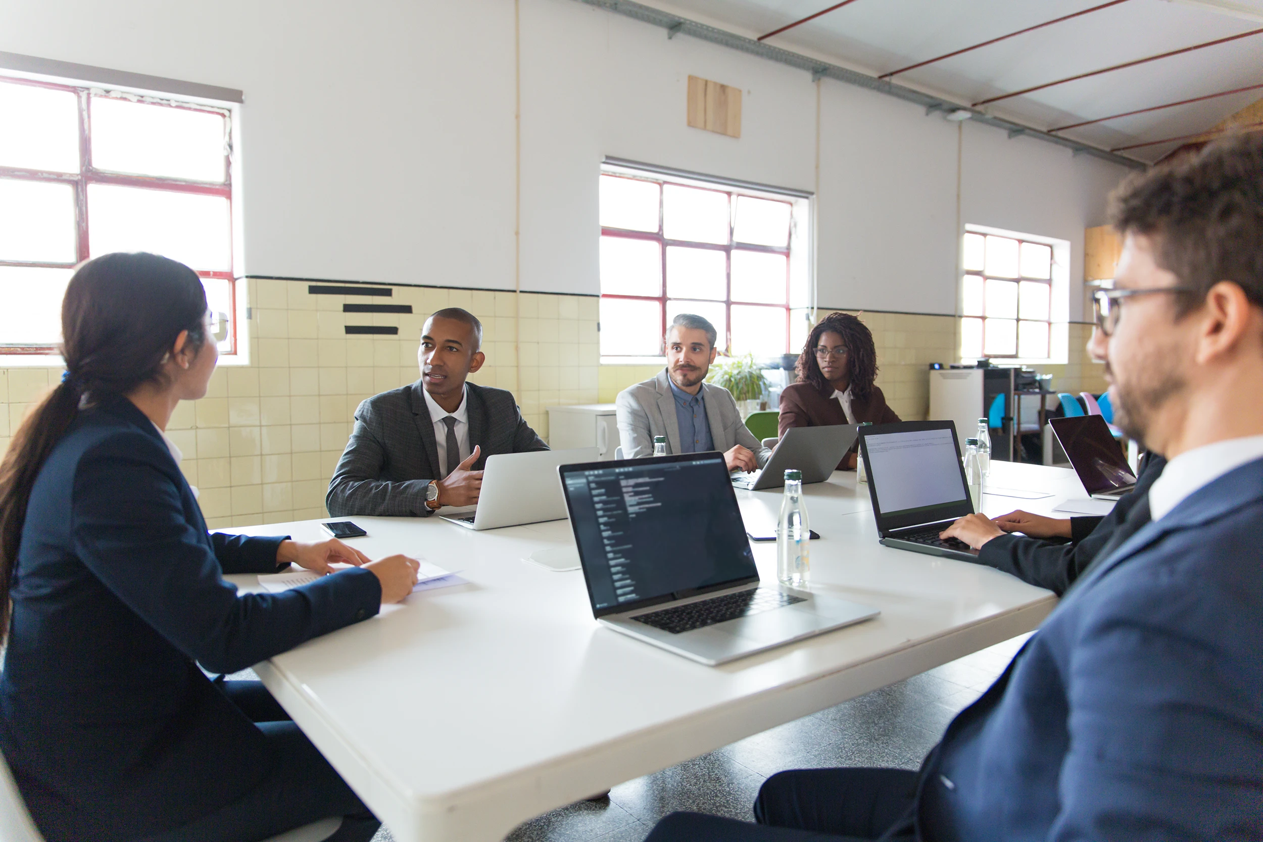 Group of analysts communicating during morning meeting Group of analysts communicating during morning meeting